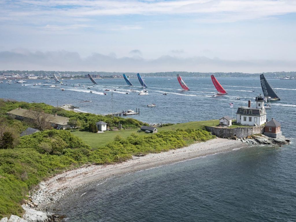 A line of colorful sailboats carried on the wind of Newport Harbor