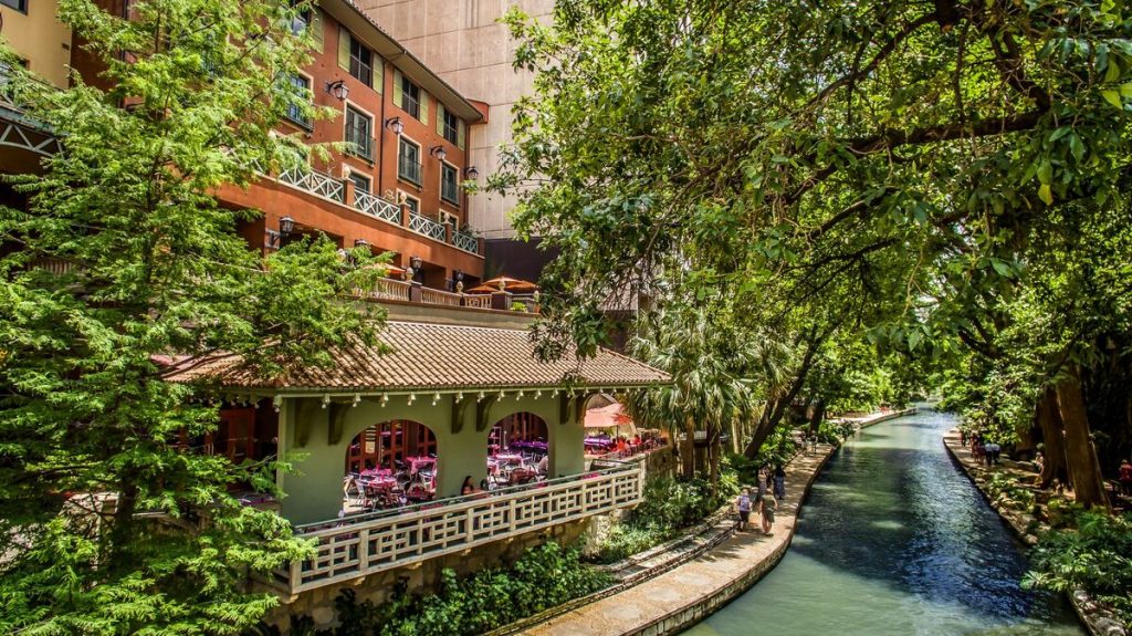 Spanish colonial inspired hotel above the green waters of the Riverwalk in San Antonio Texas